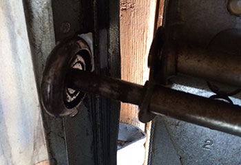 Bottom view of steel sectional garage door with old worn roller needing replacement in Danbury, CT